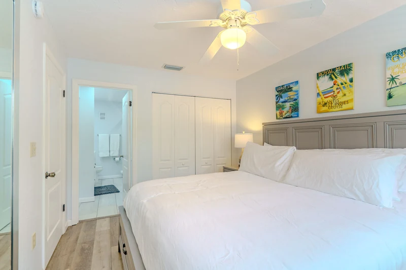 Bright bedroom with white bedding and colorful coastal prints