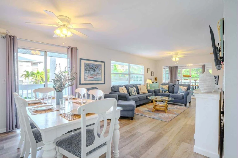 Living and dining room with coastal blue sofas and a white dining table